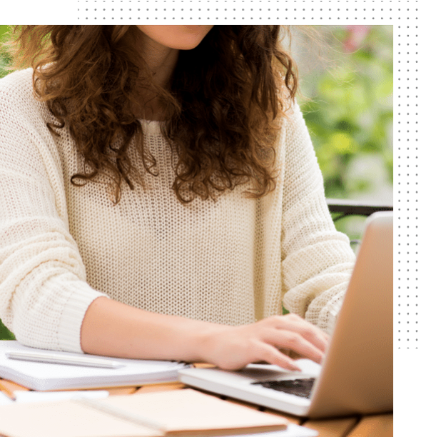 Copywriting concept. A woman types on a laptop, practicing copywriting services.